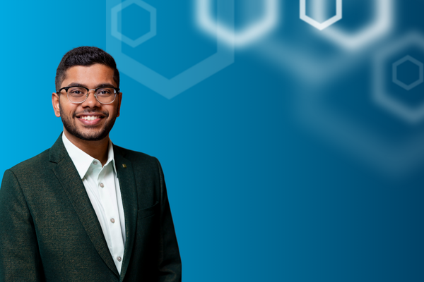 Hemanth Tadepalli pictured over a gradient blue background with white hexagons on the right.